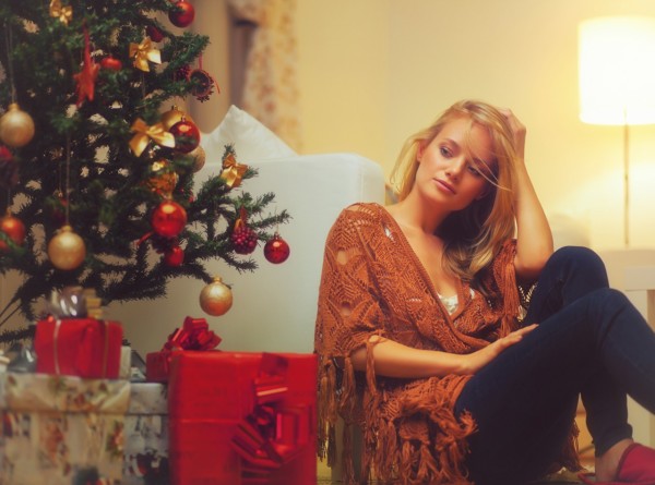Young Woman Sitting Near A Christmas Tree
